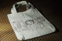 a white tote bag with a drawing on it